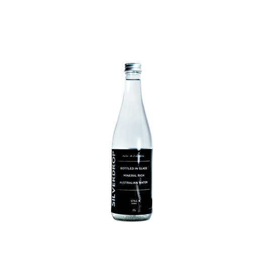 Clear glass water bottle with a black label on a white background